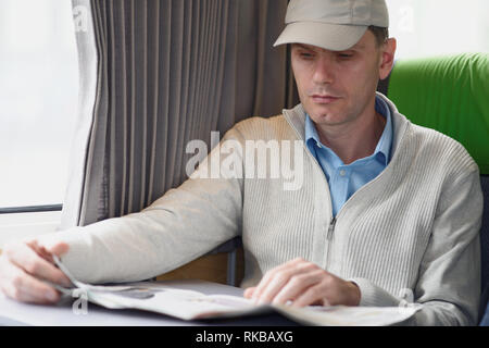 Man reading newspaper in a train Stock Photo