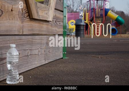 Warminster, Pennsylvania, USA - February 6, 2019: Discarded water bottle at a community park occupying the site of a former naval air base. Stock Photo