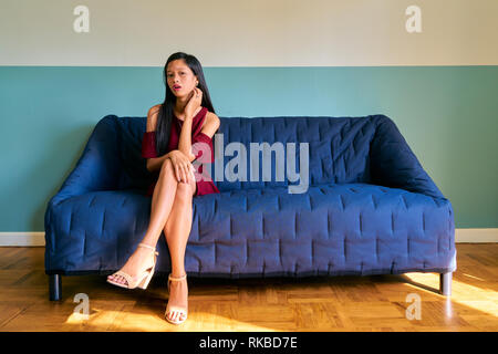 Beautiful woman posing - tired young woman sitting on the sofa Stock Photo