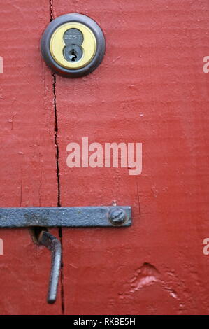 The red door is locked and cannot open without a key. Stock Photo