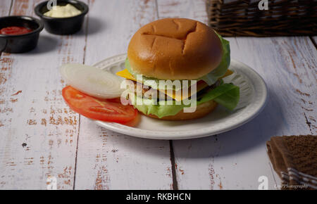 Salmon Burger with lettuce cheese tomato onion and condiments Stock Photo
