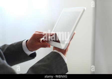 Businessman holding a touchpad pc, one finger touches e-mail Stock Photo