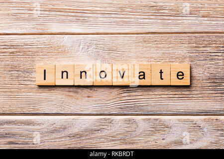 INNOVATE word written on wood block. INNOVATE text on wooden table for your desing, concept. Stock Photo