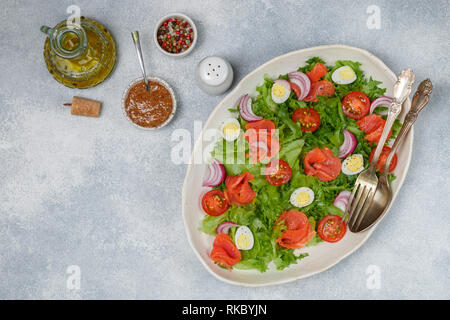 Delicious lettuce salad with salted or smoked salmon (trout) cherry tomatoes, quail eggs, red onions and spices with olive oil and mustard dressing. S Stock Photo