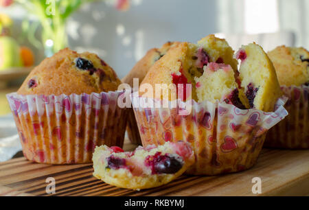 Muffins with red and black currant. paper bakeware with Valentine's day design with pink hearts. Close up, side view Stock Photo