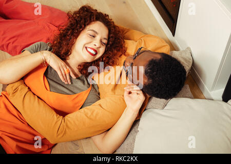 Cheerful curly red-haired wife looking at her caring loving man Stock Photo