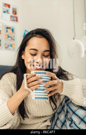 Close up of beautiful Asian woman holding big white cup of tea Stock Photo