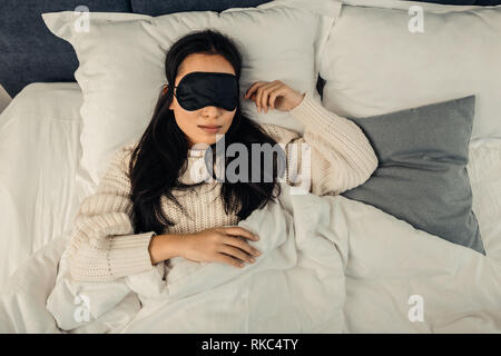 Dark-haired woman feeling relieved and relaxed while sleeping Stock Photo