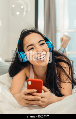 Woman feeling cheerful and relaxed while chilling at home Stock Photo