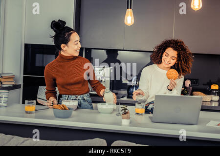 Two friends making cereals with milk in the morning Stock Photo