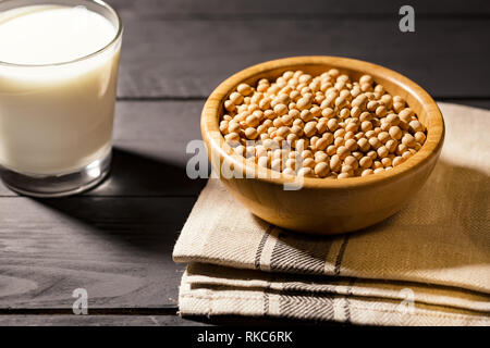 Soymilk and soyseeds on darck background, soft focus. Vegan protein source. Superfoods and Healthy food clean eating. Stock Photo