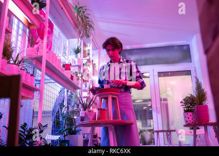 Handsome dark-haired worker being interested in garden works Stock Photo