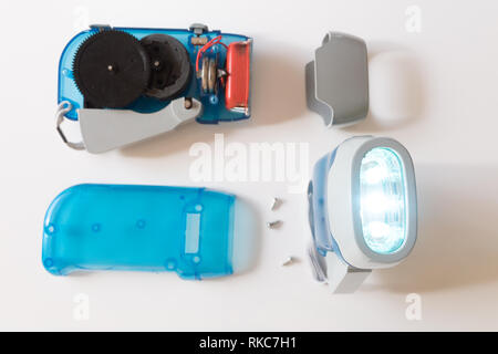 Interior of a dyno torch, dynamo wind up flashlight hand pressing crank, squeezing a handle, mechanically powered three LED flashlight Stock Photo