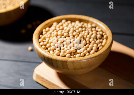 Soybeans in wooden bowl on darck background, soft focus. Vegan protein source. Superfoods and Healthy food clean eating. Stock Photo