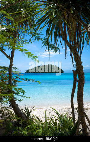 Tropical Island view through trees on white sand Bonbon Beach - Romblon, Philippines Stock Photo