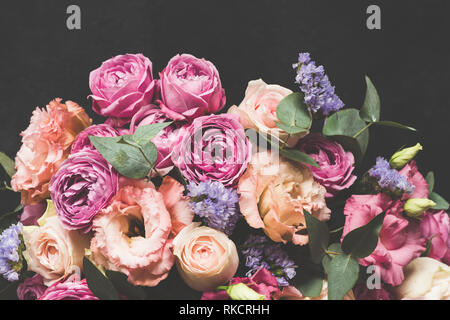 Bouquet of pink and purple peonies with eucalyptus on black concrete background. Toned image, Pastel bouquet of flowers Stock Photo