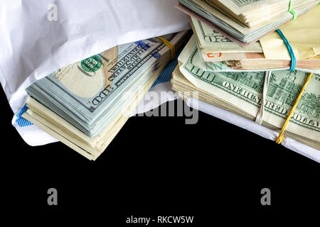 Bundle of american dollar banknotes in white envelope on wooden table. Secondary black economy concept. Envelope wages. Bribery and economical crime Stock Photo
