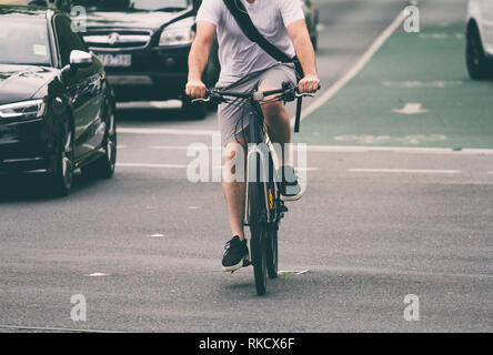 Man cycling on city street Stock Photo