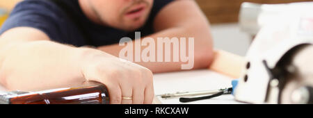 Arm of drunken worker in yellow helmet Stock Photo