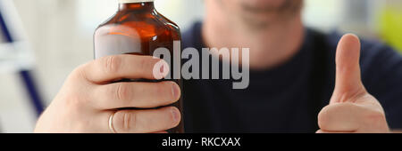 Arm of drunken worker in yellow helmet Stock Photo