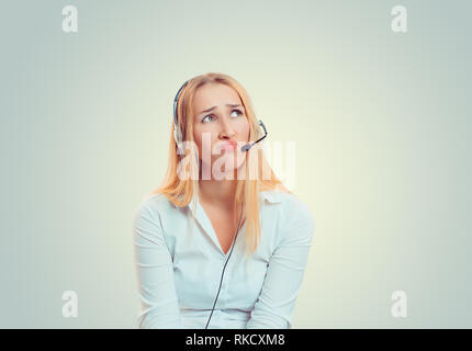 Woman in headset annoyed upset sad looking  up Stock Photo