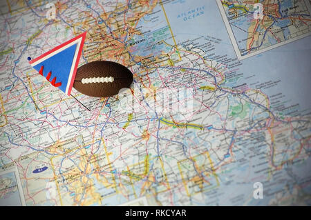 Macro shot of a flag and football placed on Gillette Stadium in a map. Stock Photo