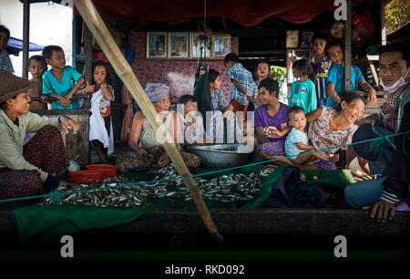 Tonlé Sap Lake,  Cambodia. 17th December, 2018. Family members work together in a floating house cleaning fish while socializing. Photo: Bryan Watt Stock Photo