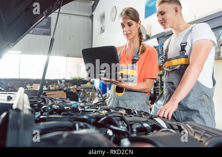 Female auto mechanic checking the engine error codes Stock Photo