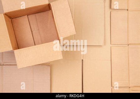 Open cardboard box on used corrugated striped cardboard boxes parts background Stock Photo