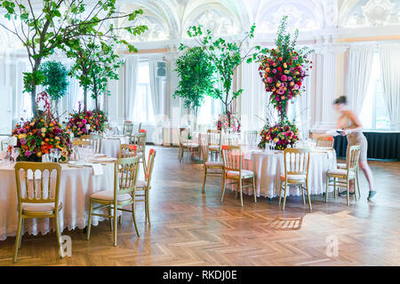 Wedding table decoration. Beautiful bouquet of flowers on the table and water preparing tables for dinner Stock Photo