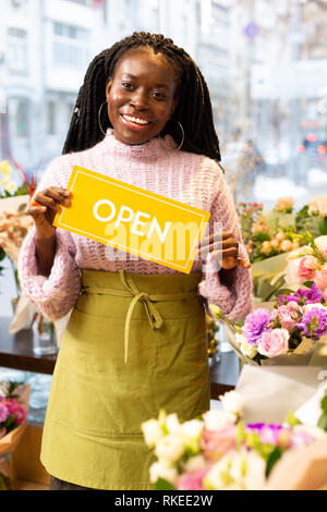 Charming brunette worker demonstrating yellow card for visitors Stock Photo