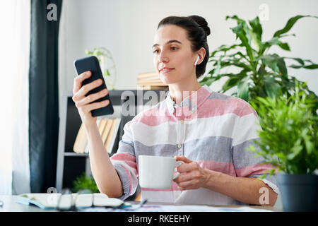 Woman Using Smartphone during Coffee Break Stock Photo