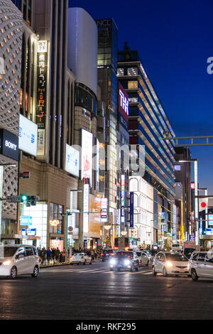 Tokyo, Ginza, night. Traffic turning at the 4-chome junction with view along buildings and the Ginza Six luxury shopping complex in the background. Stock Photo