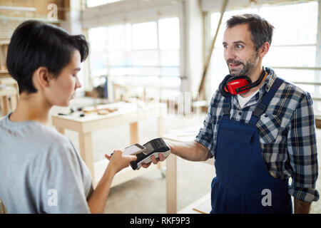 Customer paying builder using nfc technology Stock Photo