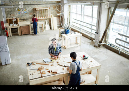 Carpentry workers making wooden frames in workshop Stock Photo