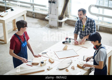 Carpenters chatting while working with wood Stock Photo