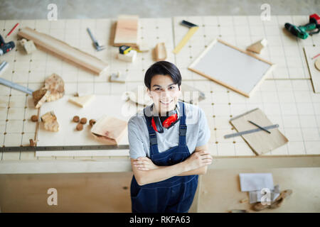Cheerful lady carpenter in own workshop Stock Photo