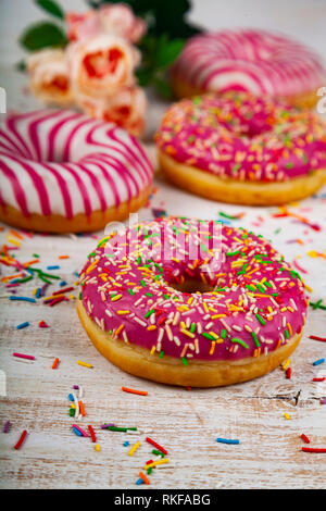Pink donuts on a wooden background. Delicious dessert. Stock Photo