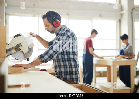 Using circular saw in workshop Stock Photo