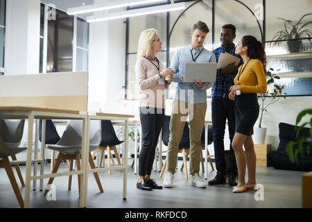 Colleagues analyzing online data in coworking space Stock Photo