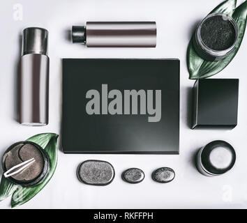 Black beauty box and various black and brown cosmetic product in jars and bottles with branding mock up.  Eye patch. Snail mucin cosmetic set and char Stock Photo