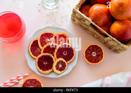 Glass of fresh blood orange juice on pink background. Selective focus Stock Photo