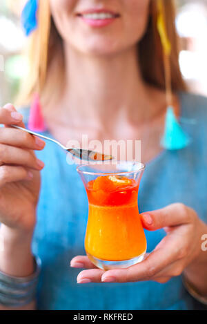 Woman eating citrus cumquat jelly dessert. Close up Stock Photo