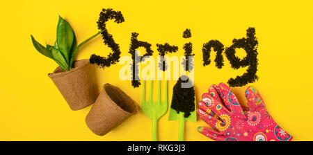 The text of the word spring is laid out on a yellow spring background with various garden accessories and tools. Stock Photo