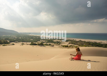 Girl in red relaxing in sandy desert Stock Photo