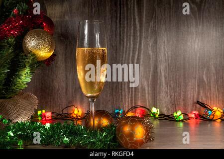 https://l450v.alamy.com/450v/rkgfd4/champagne-glass-with-christmas-balls-lights-and-tree-wooden-background-rkgfd4.jpg