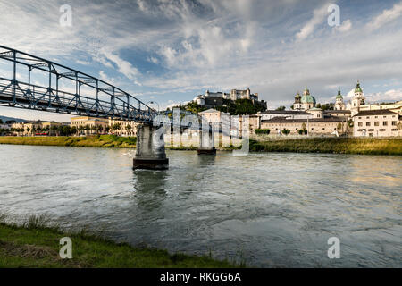 Mozartsteg bridge and Old Town across the Salzach river with the Hohensalzburg Fortress in the distance, Salzburg, Austria. Stock Photo