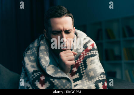 handsome man coughing while having flu at home Stock Photo