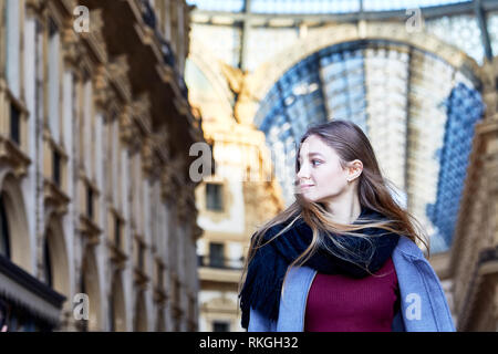 Girl daydreaming while walking inside of Galleria Vittorio Emanuele II in Milan Italy Stock Photo