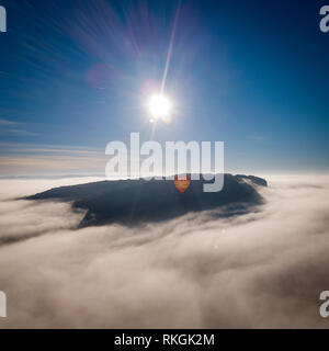 Hot air balloon flying over fog near Beynac Chateau, Dordogne, Aquitaine, France Stock Photo